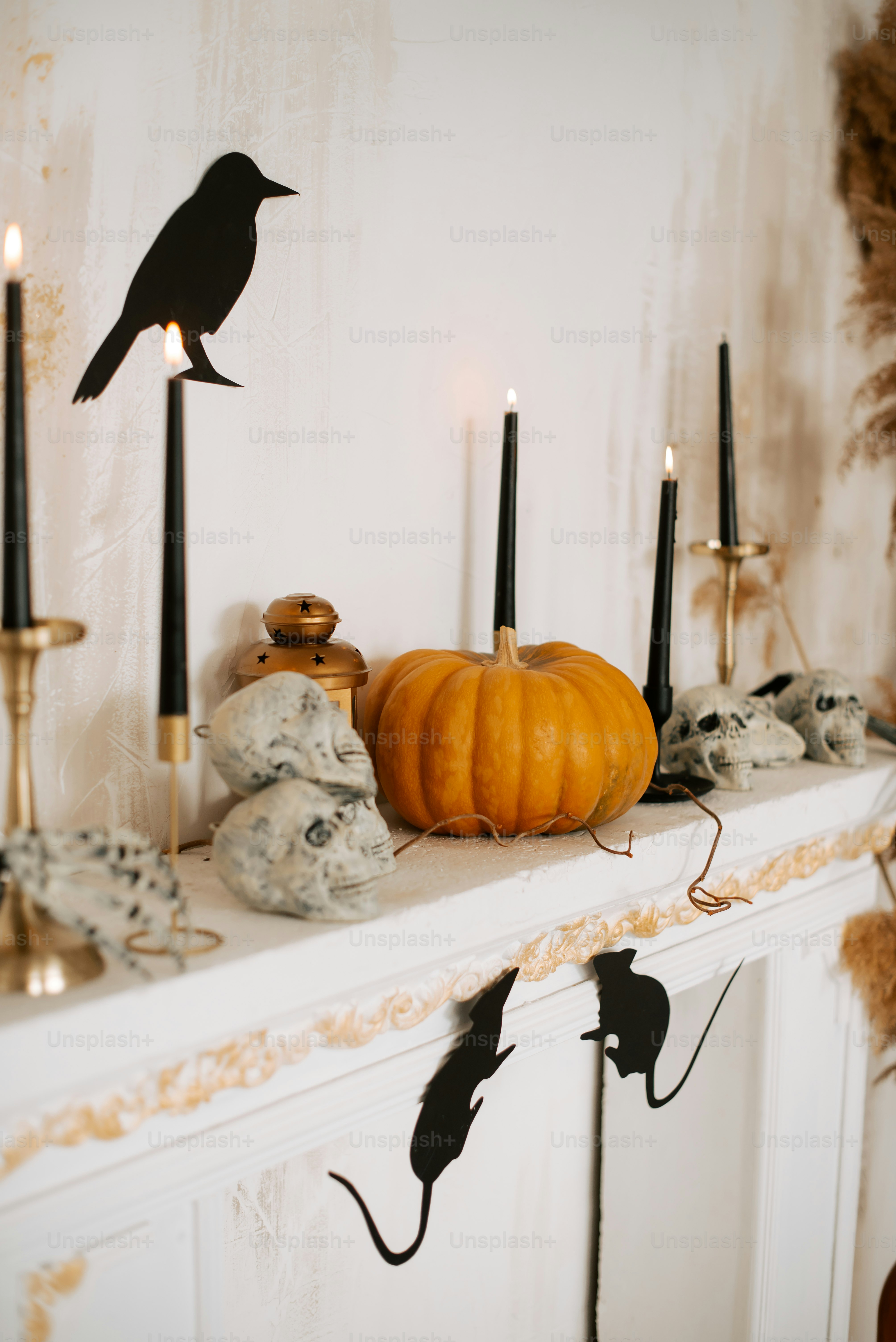Halloween mantelpiece with pumpkin, skulls, and black decorations.