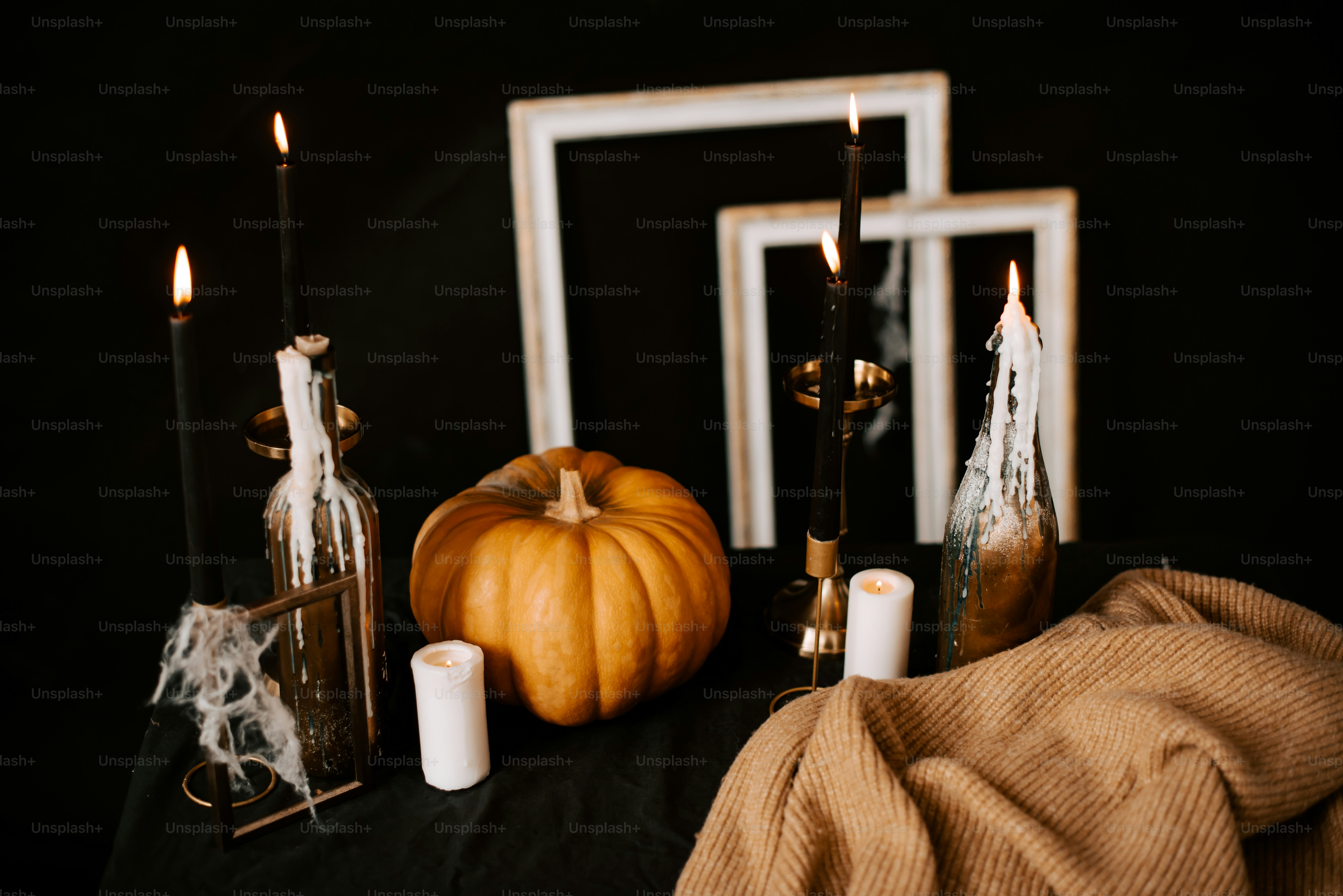 a black table topped with candles and a pumpkin