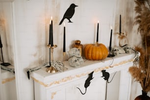 a mantle with candles and a bird on it