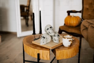 a wooden table topped with two skulls and a cup of coffee