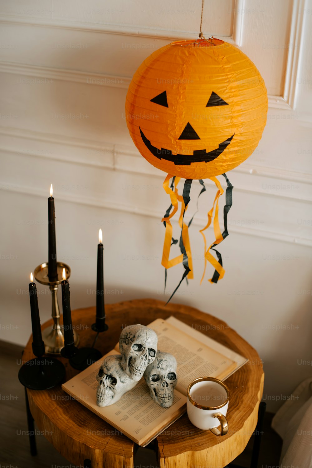 a wooden table topped with two skulls and a lantern
