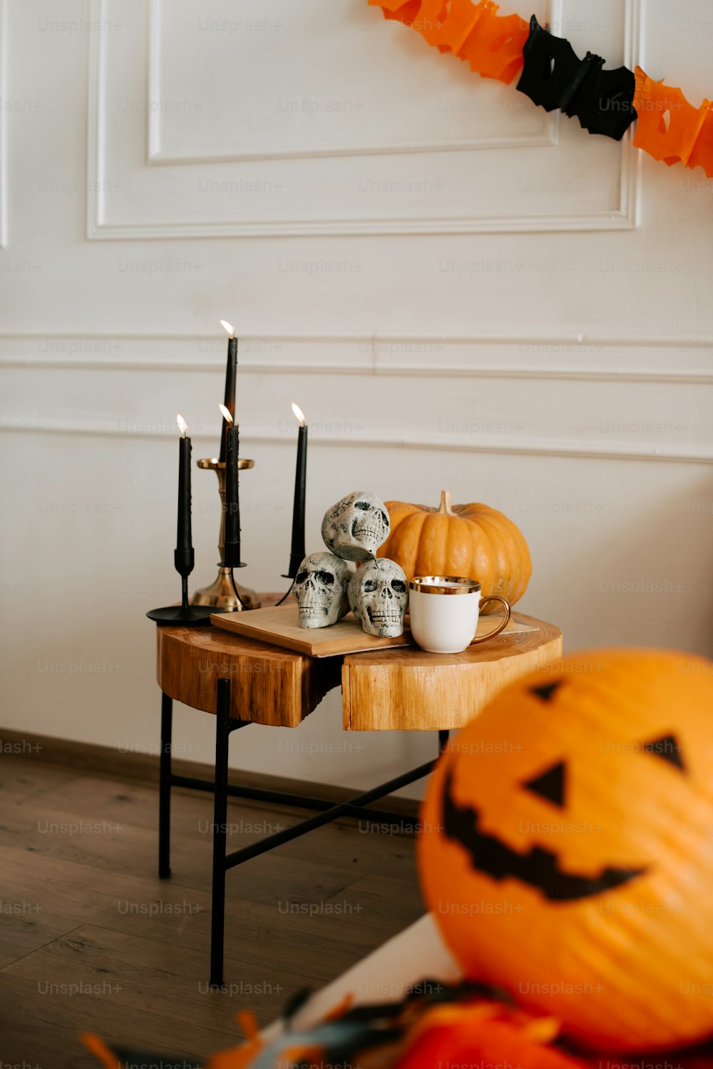 a wooden table topped with halloween decorations and candles