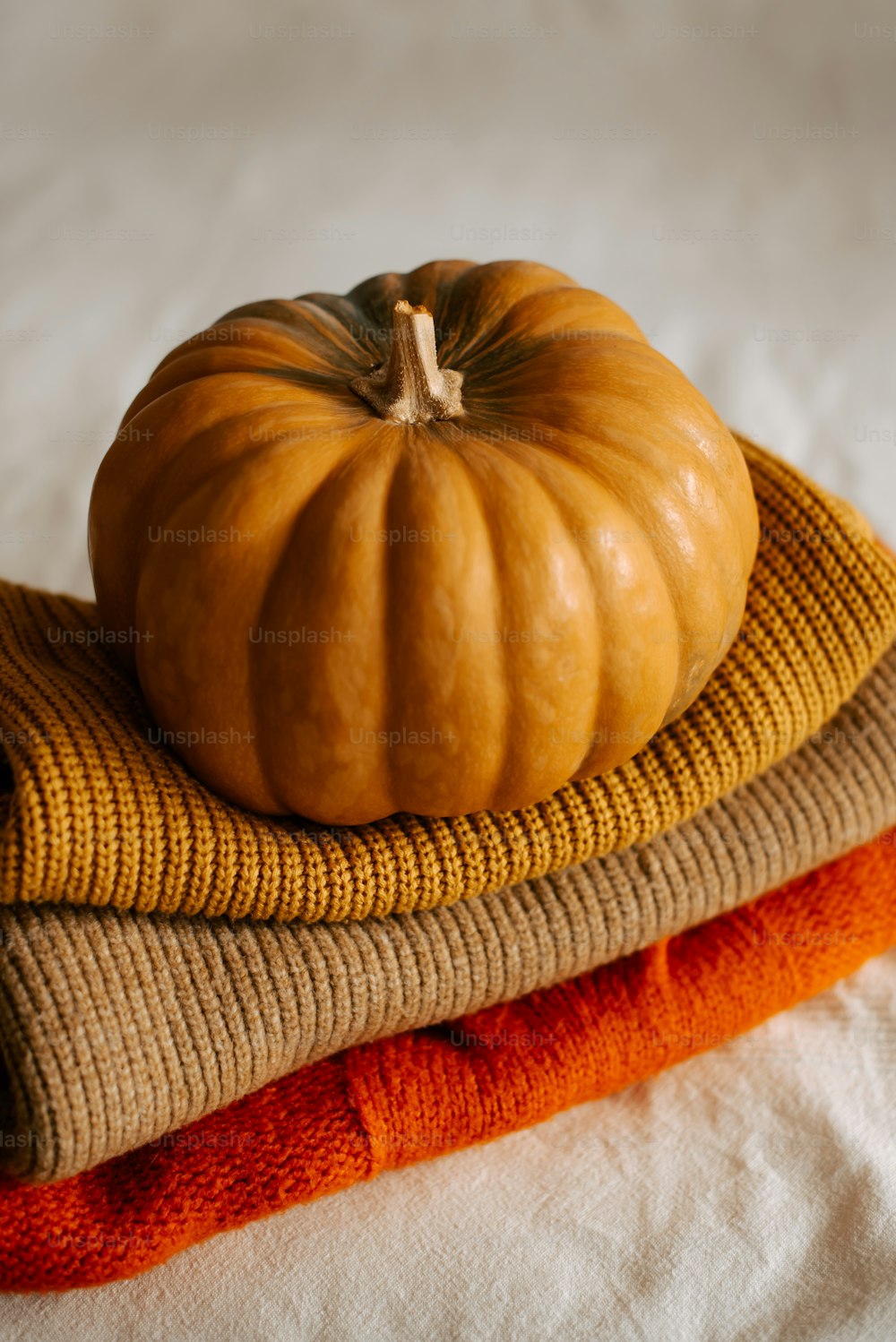 a pumpkin sitting on top of a pile of towels