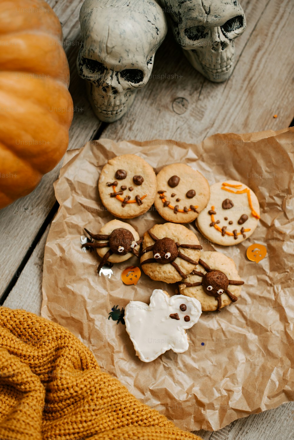 a table topped with halloween cookies and skulls