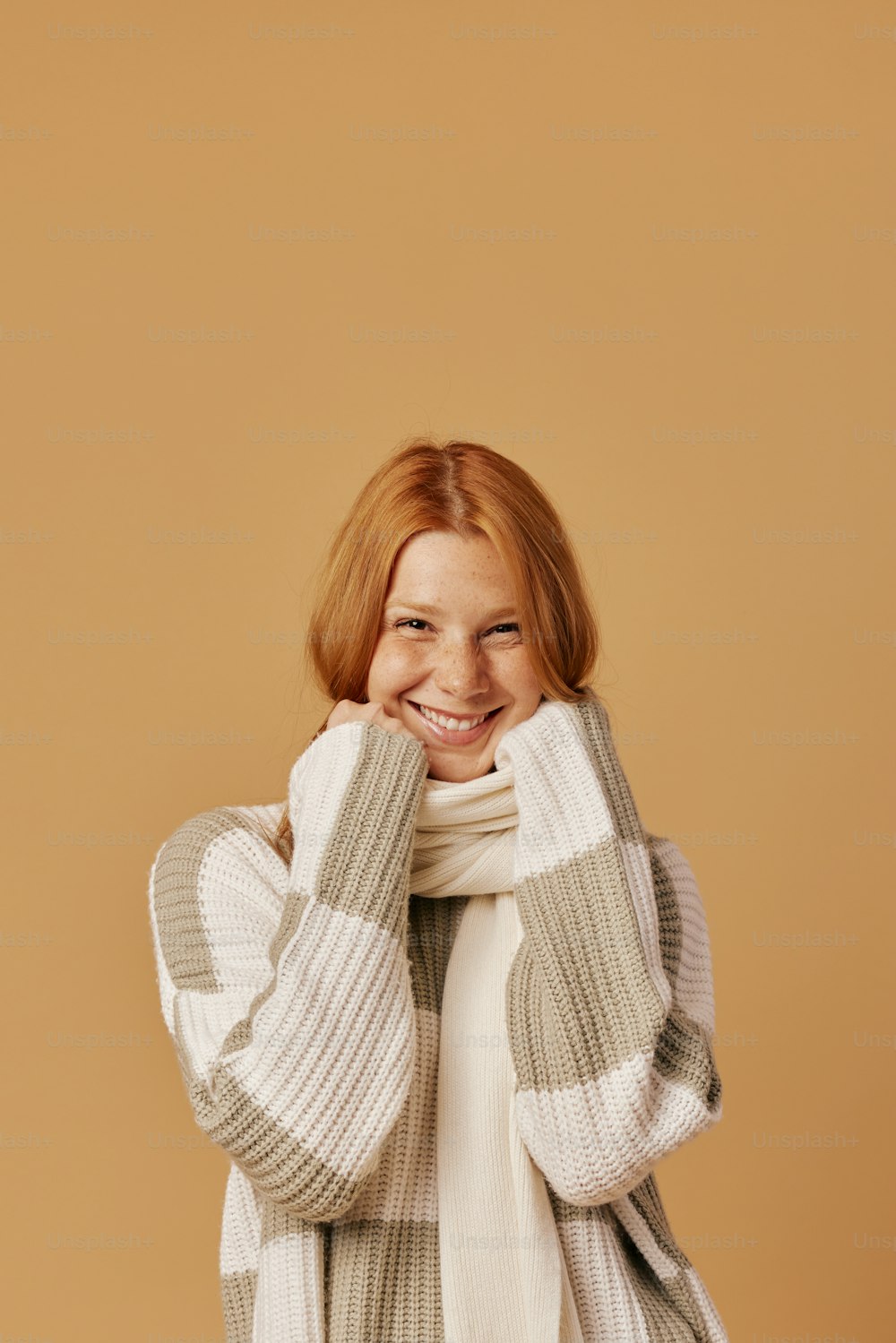 a smiling woman in a sweater and scarf