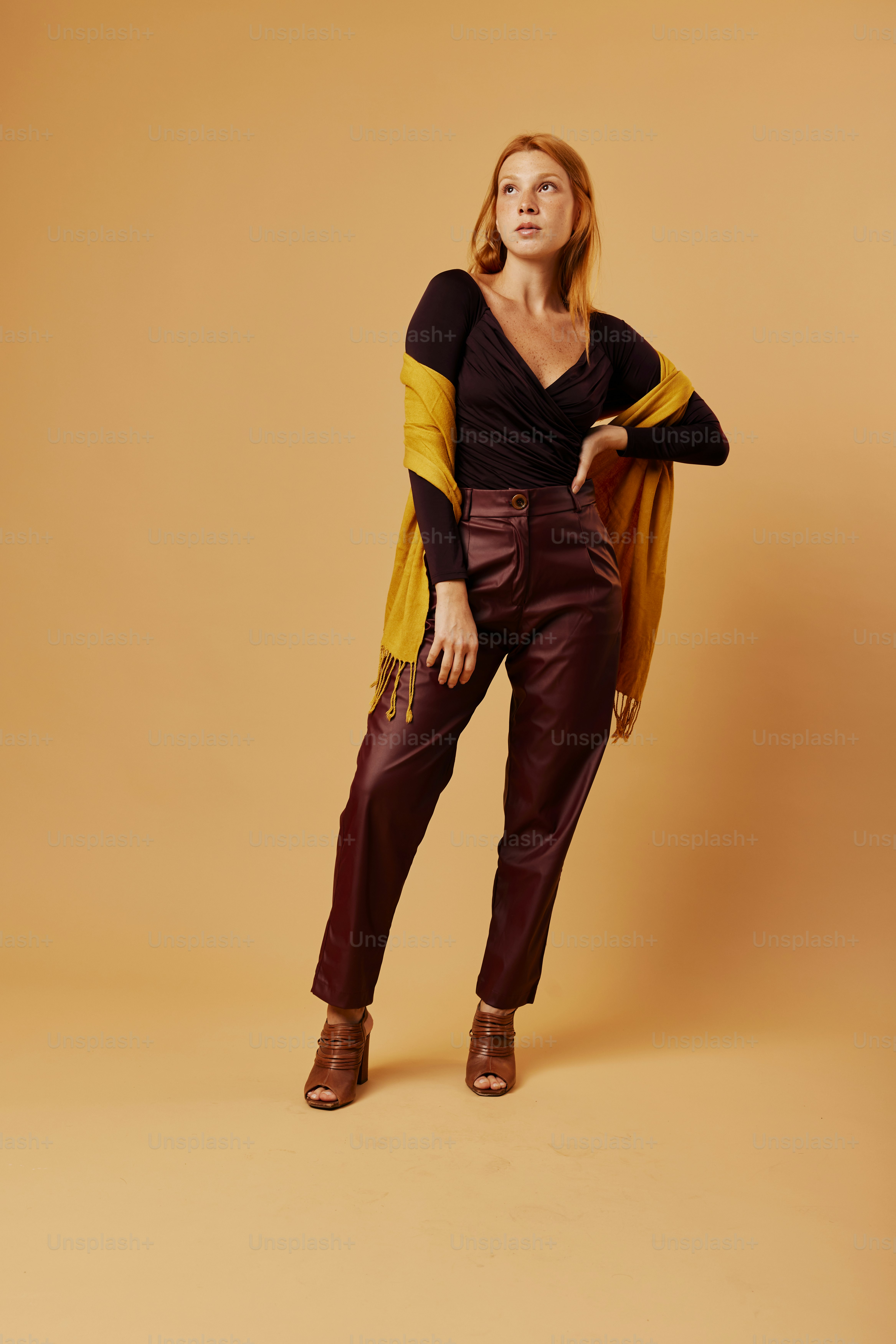 a woman in a black top and brown pants