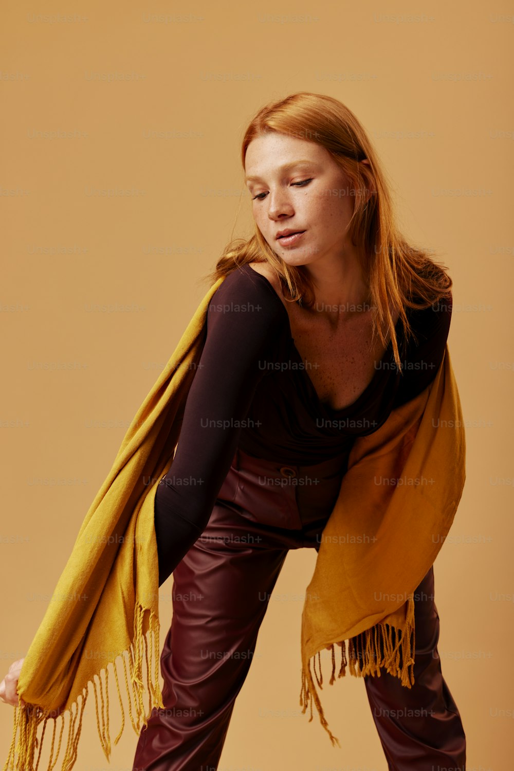 a woman in leather pants and a yellow scarf
