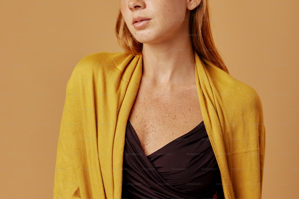 Eine Frau in einem schwarzen Oberteil und einer gelben Strickjacke