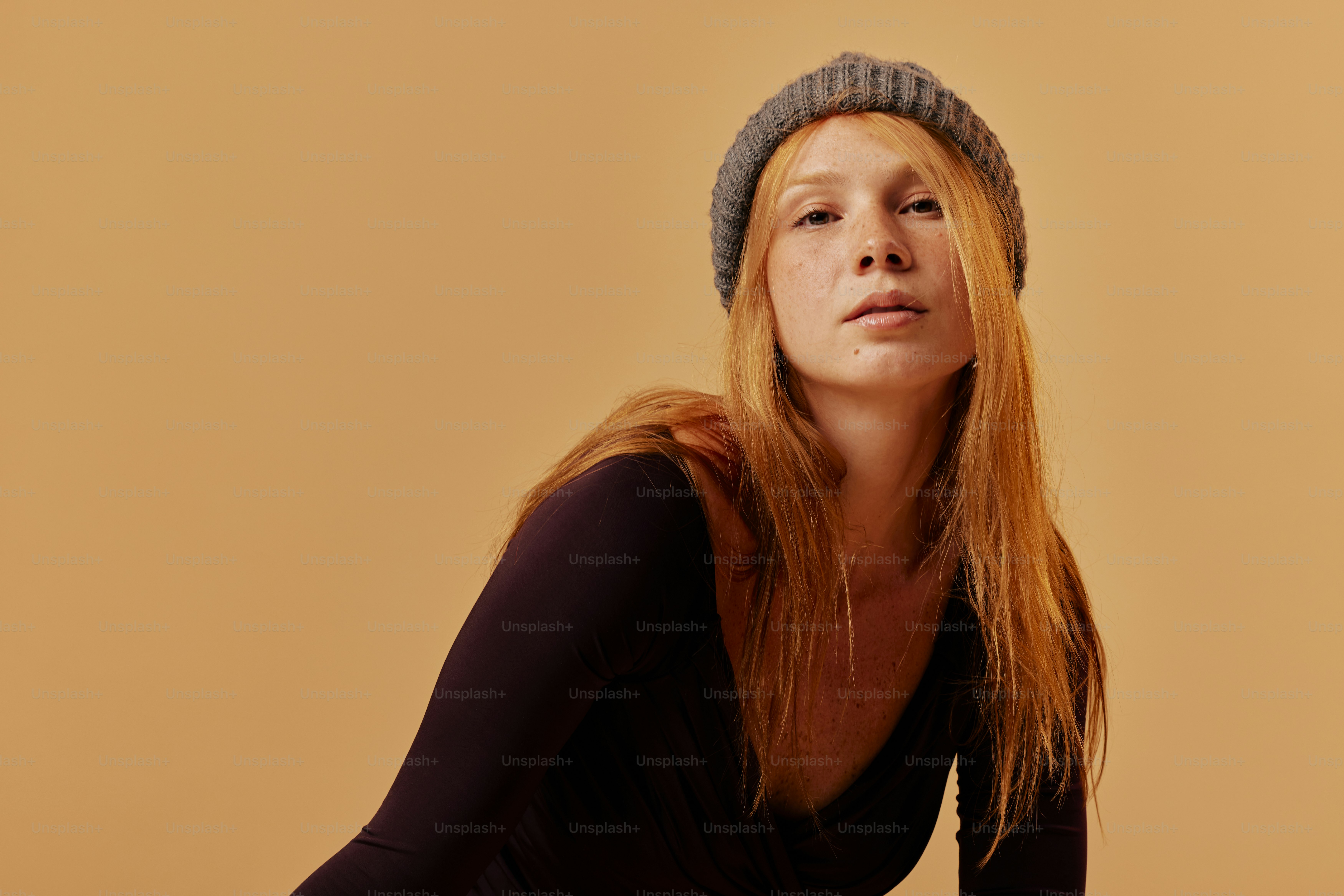 a woman with long red hair wearing a hat
