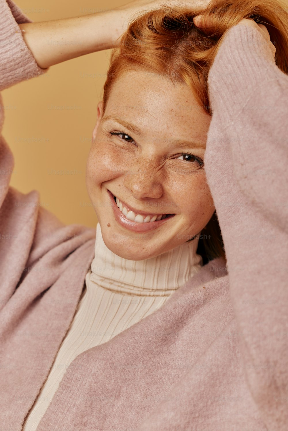 Una donna con i capelli rossi sorride per la macchina fotografica