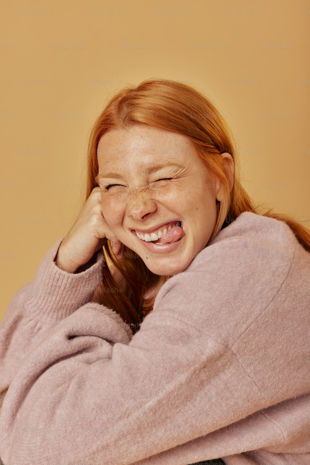 a woman is laughing and holding her head with her hands