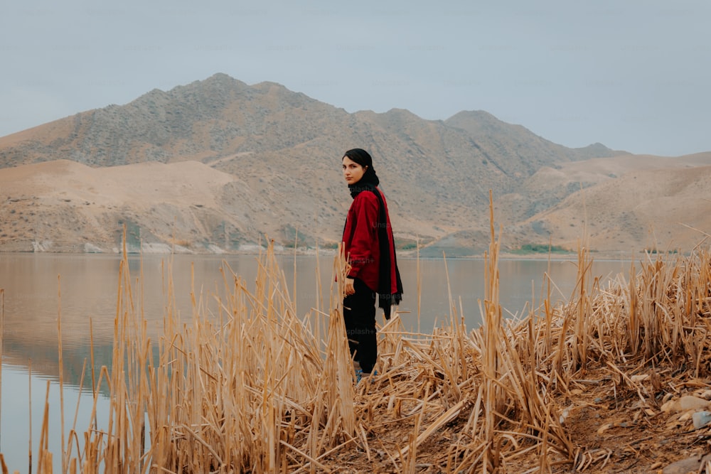 a woman standing in front of a body of water