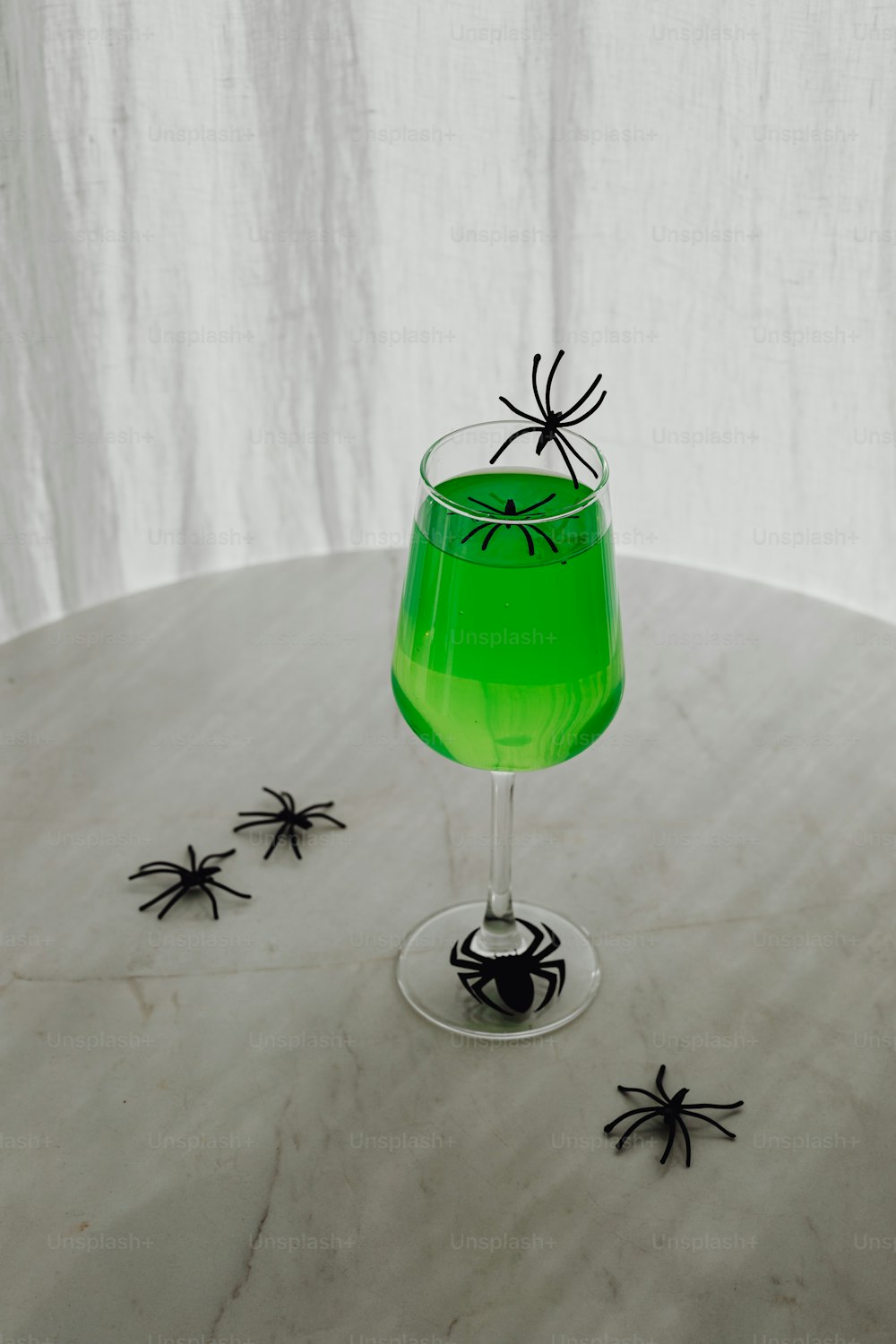 a green drink with a spider on the rim