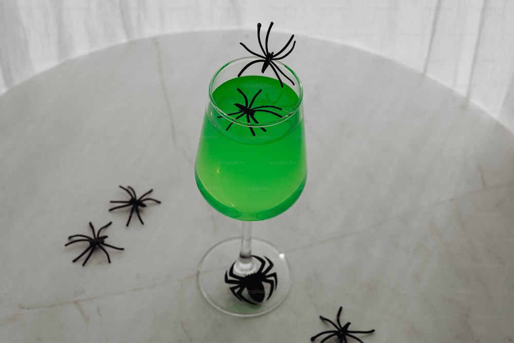 a green drink with a spider on the rim