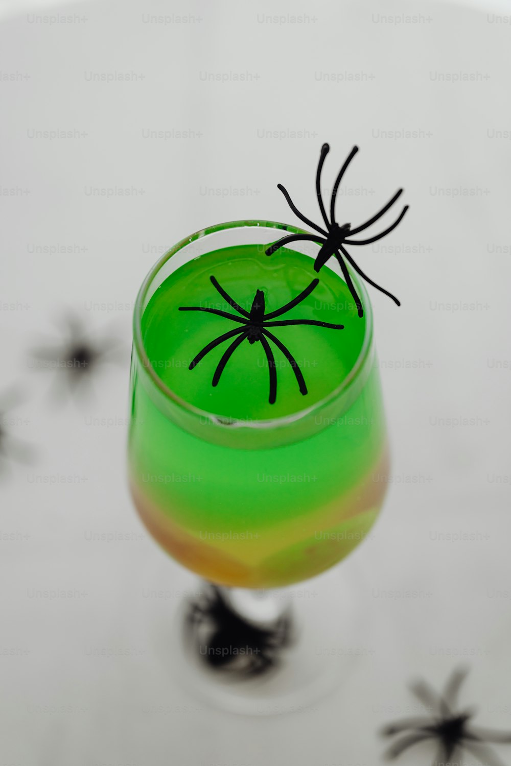 une boisson verte avec une araignée noire dessus
