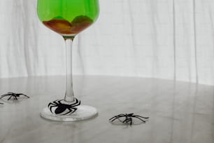 a green drink with a spider on the rim