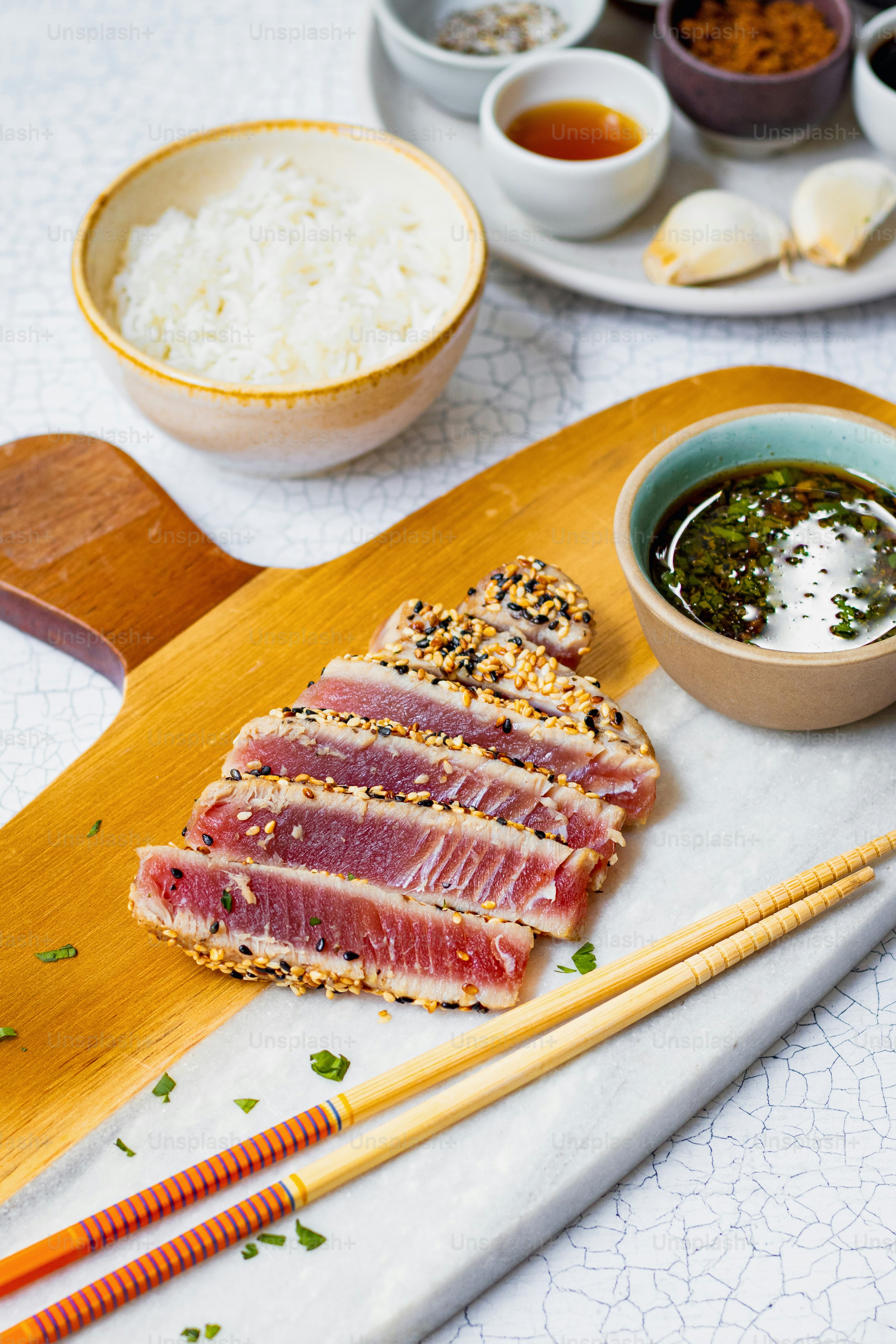 a plate of food with chopsticks and a bowl of rice