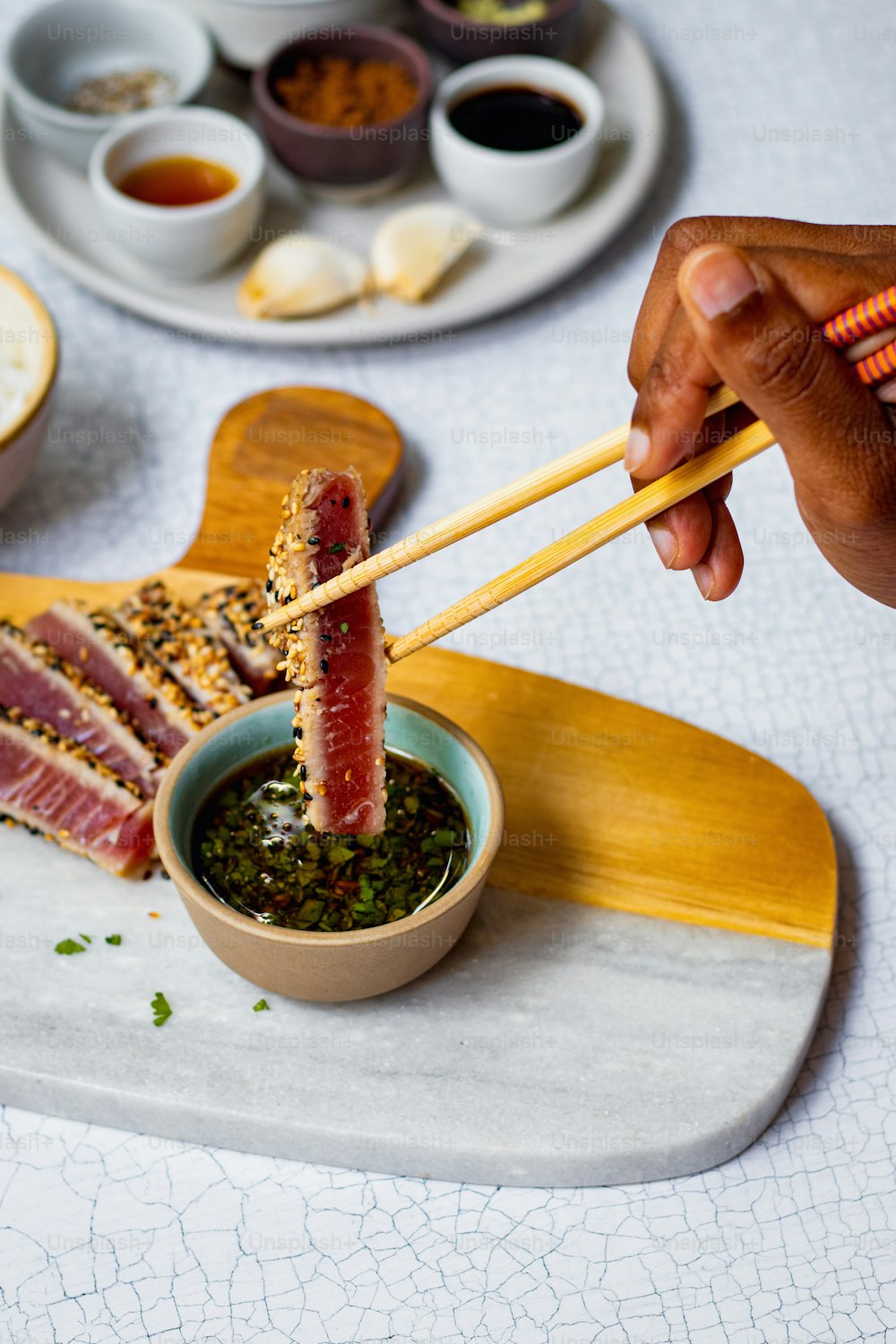 a person holding chopsticks over a bowl of food