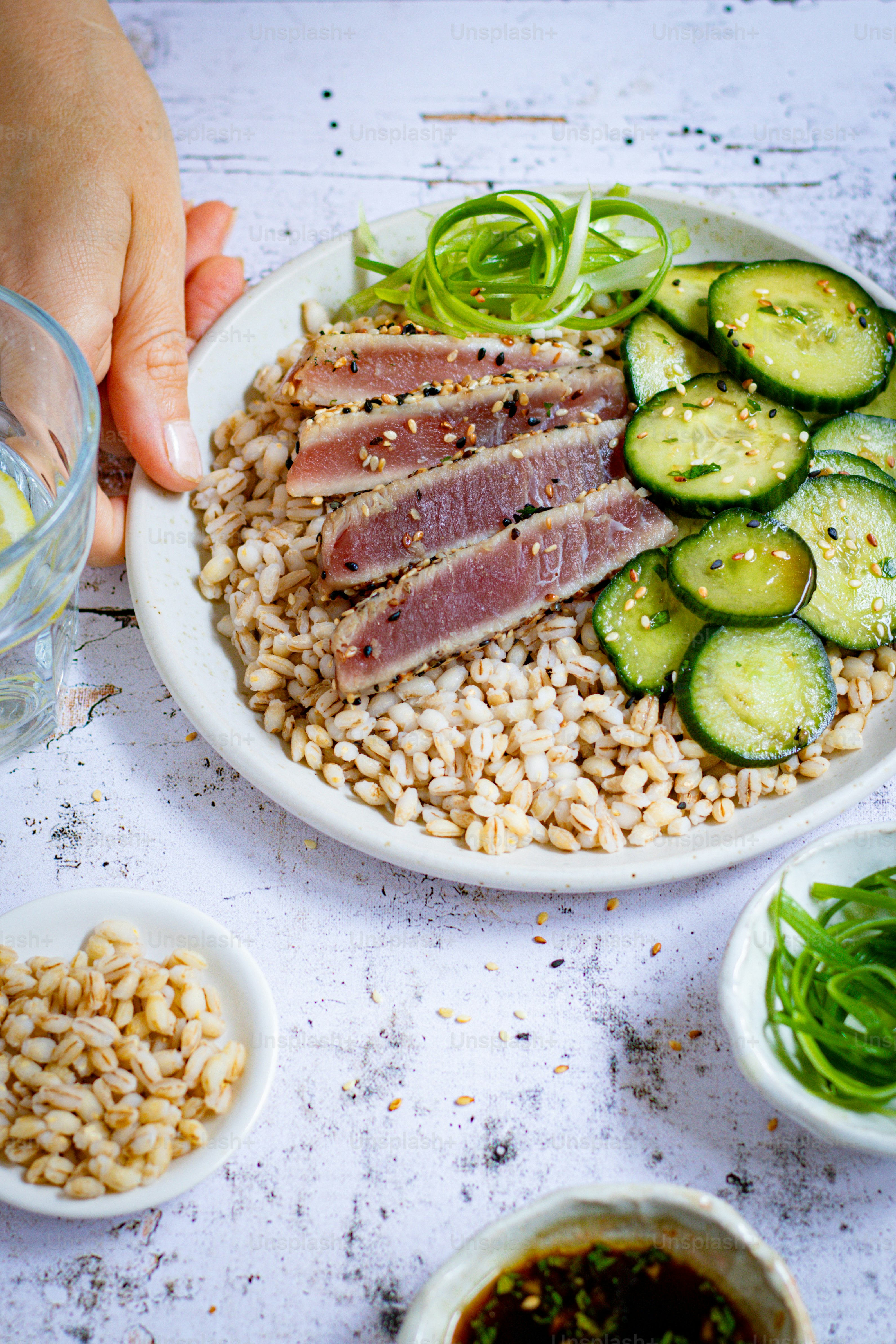 a plate of food with meat, rice, and cucumbers