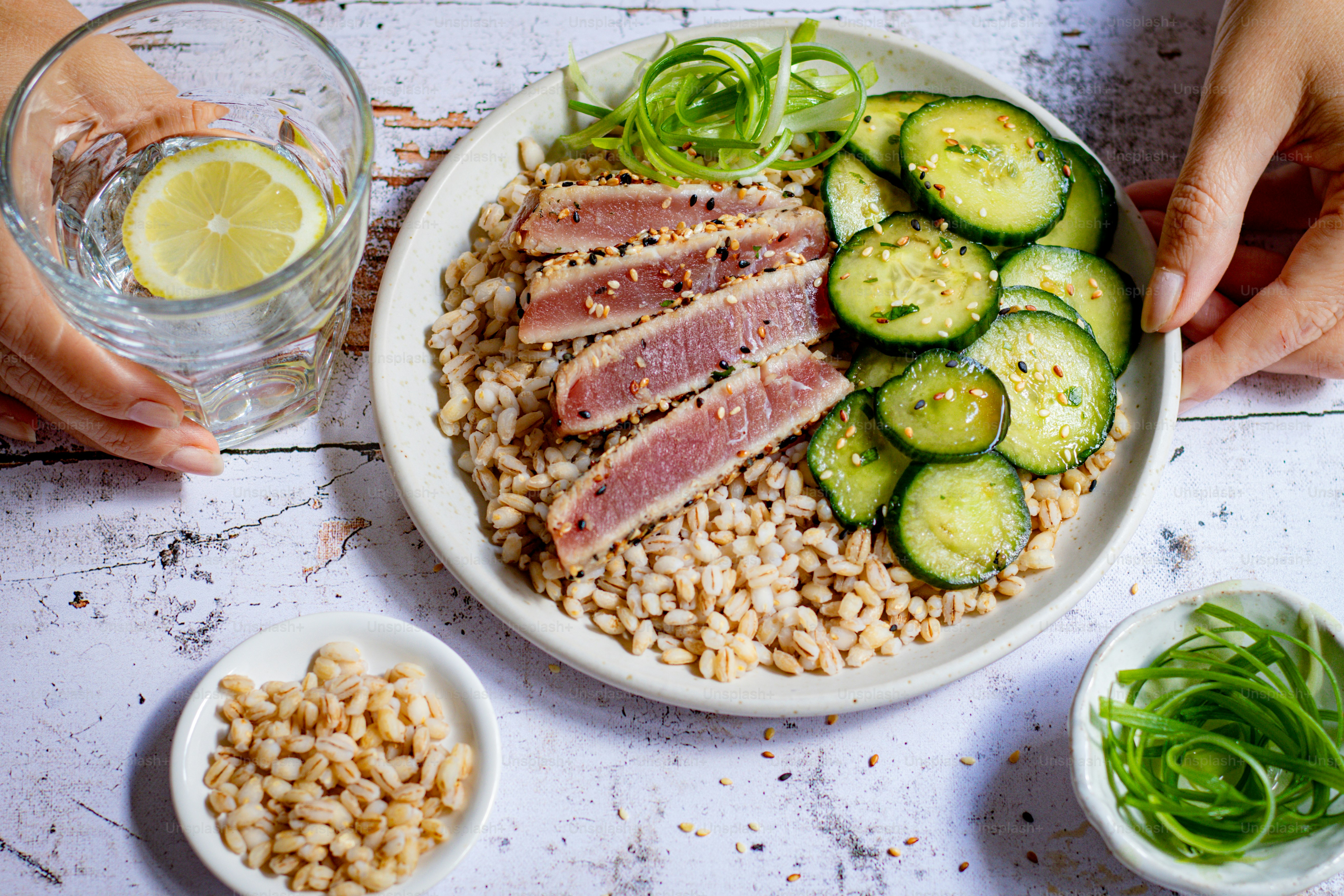 a plate of food with meat, rice, and cucumbers