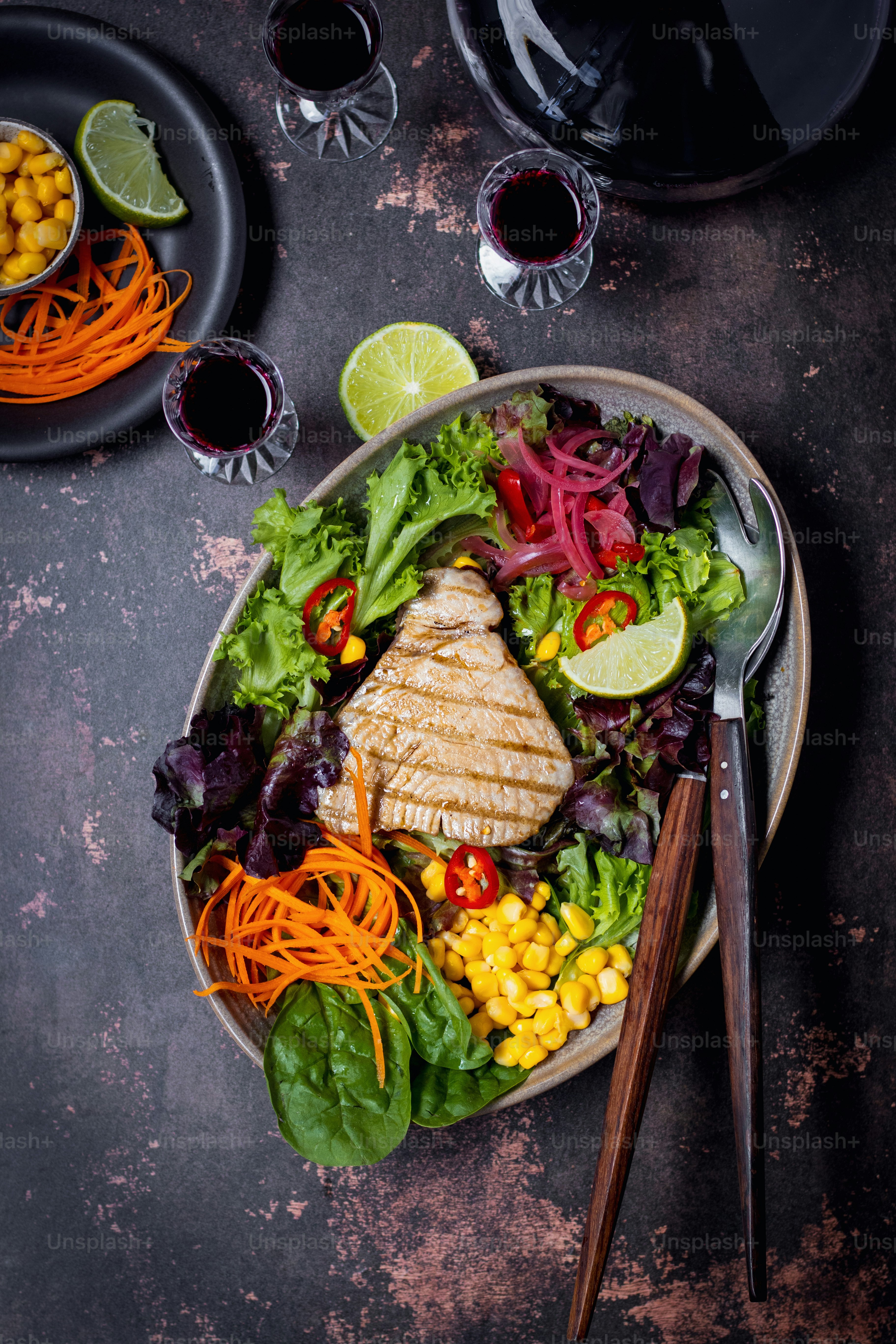 a bowl of salad with chicken, carrots, corn, lettuce and
