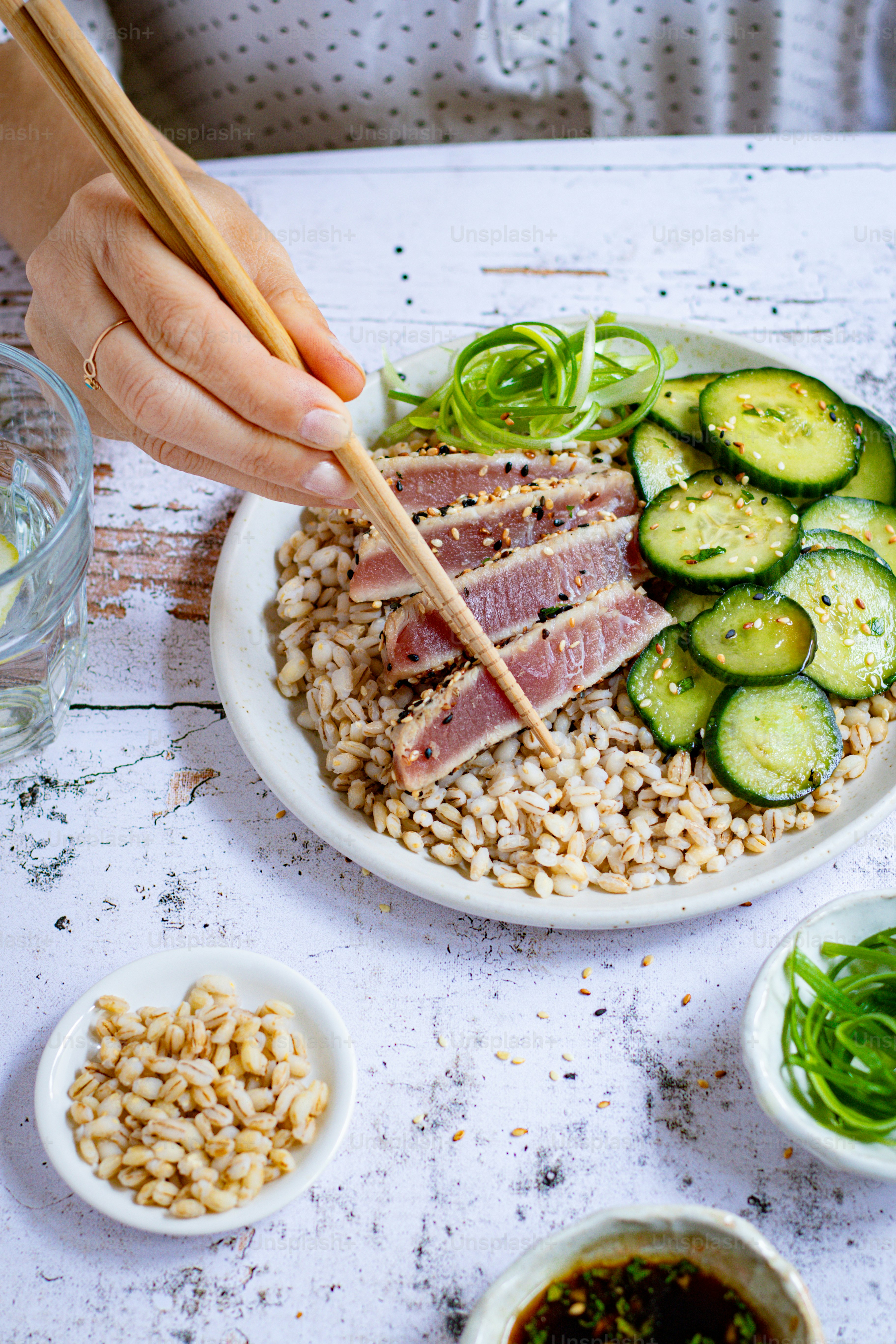 a person holding chopsticks over a plate of food