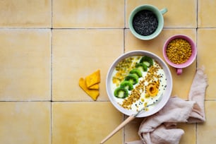 a bowl of yogurt with kiwis and other toppings