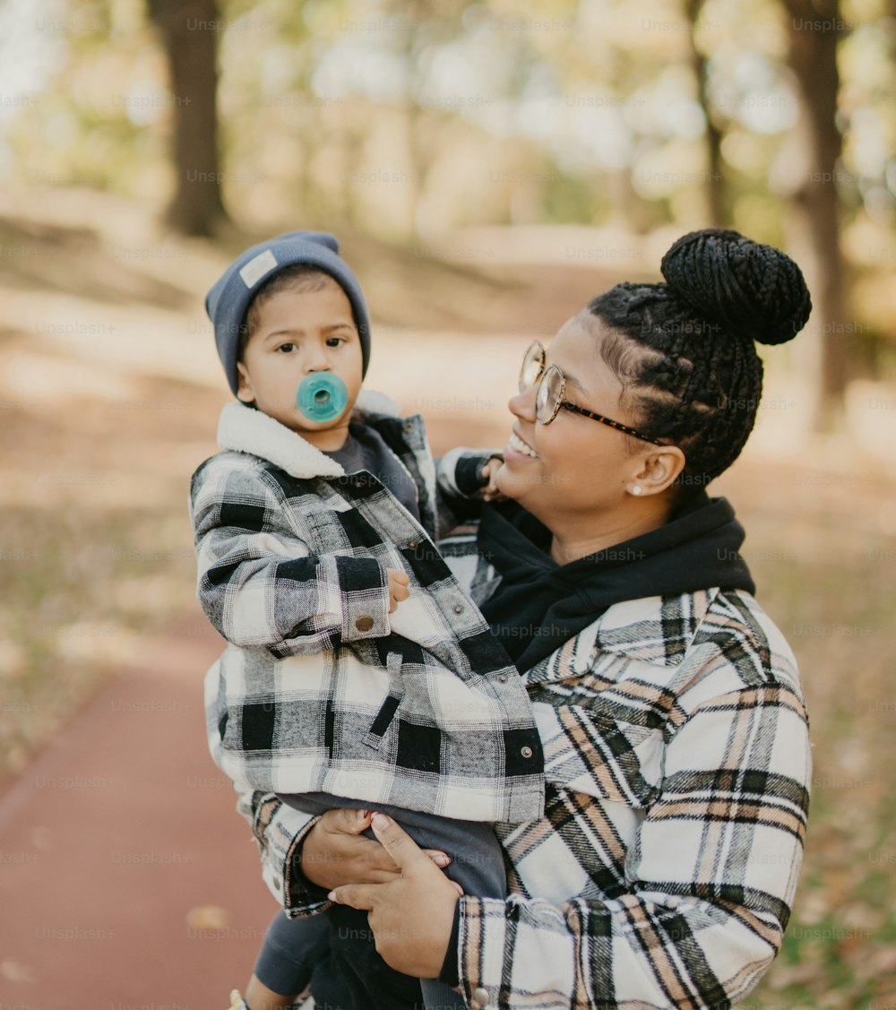 a woman holding a child with a pacifier in her mouth