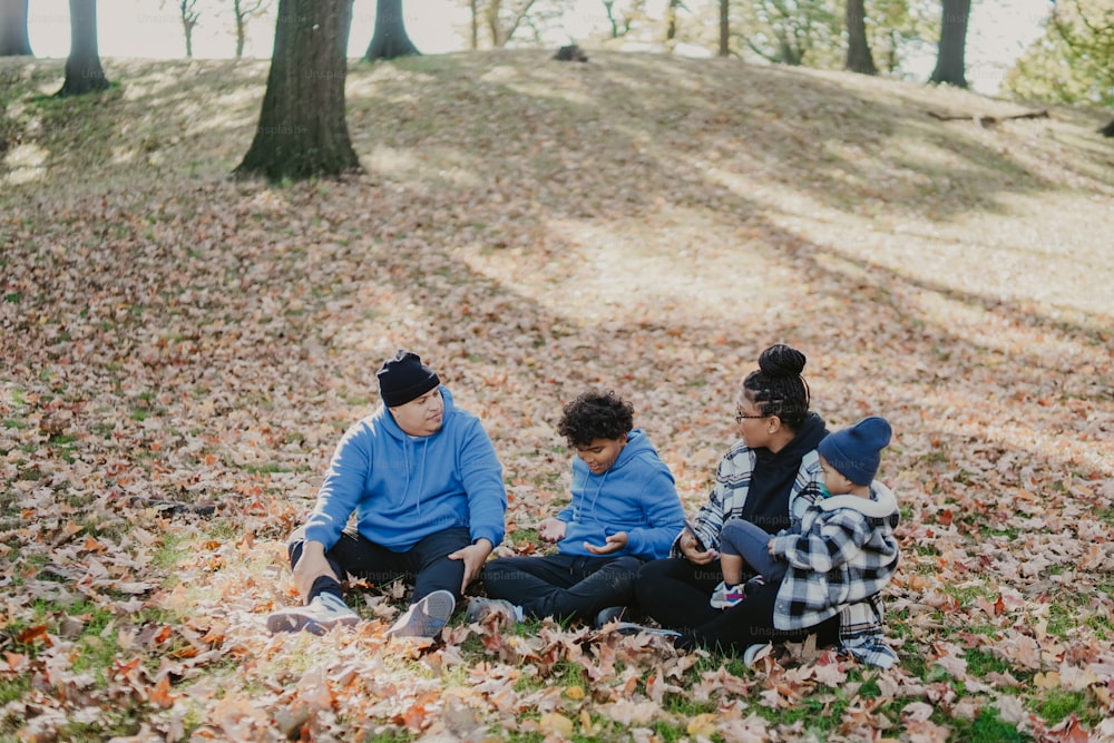 um grupo de pessoas sentadas em cima de uma pilha de folhas