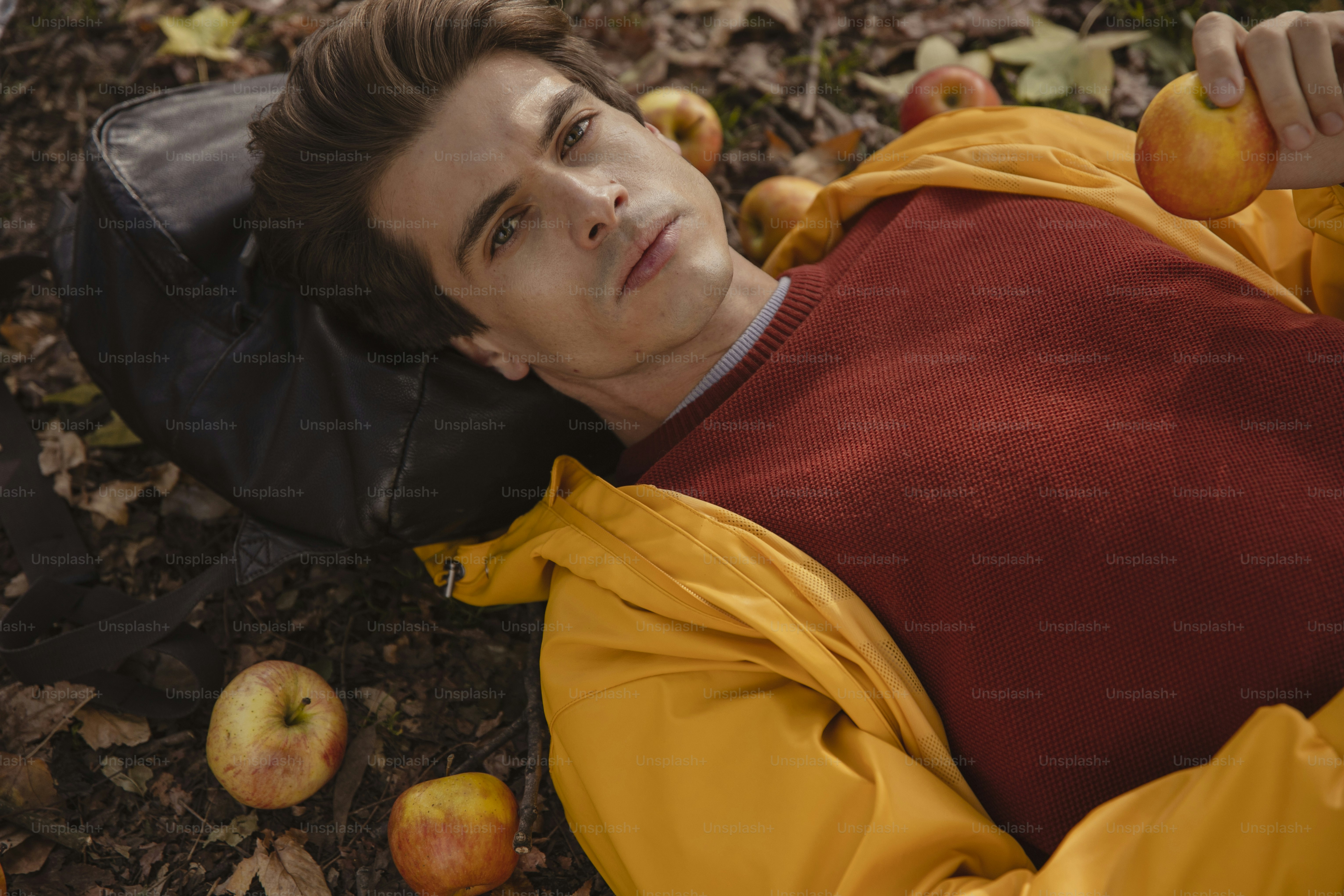 Un homme allongé sur le sol à côté de pommes