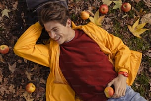 a man laying on the ground with an apple in his hand