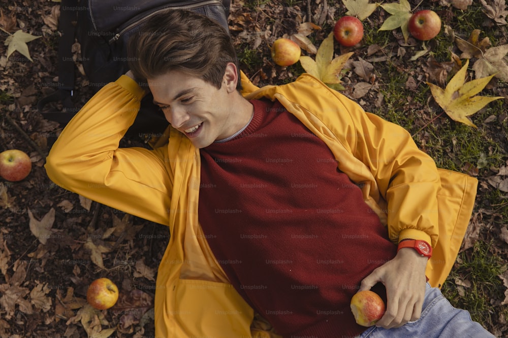 한 남자가 손에 사과를 들고 땅에 누워 있다