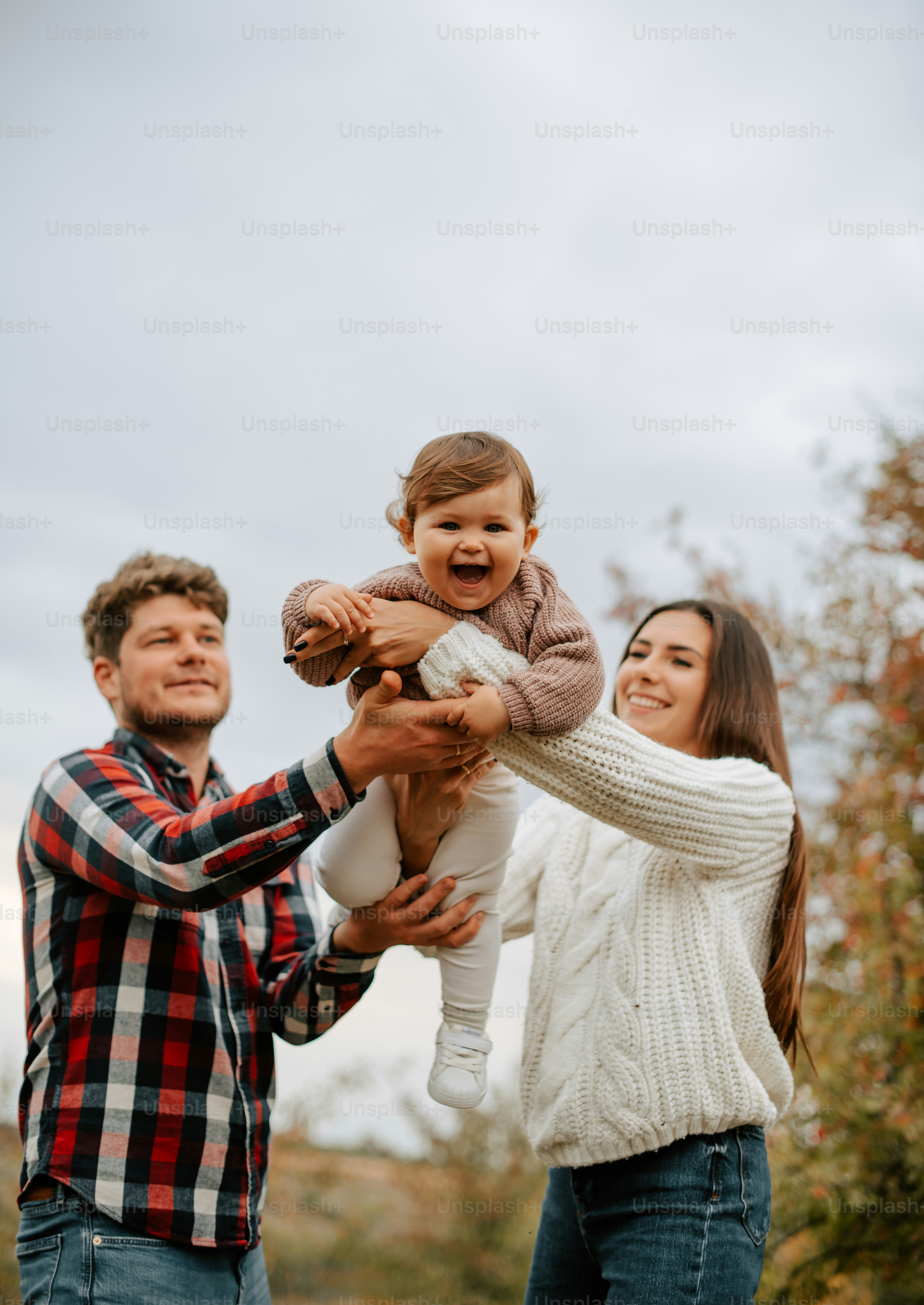a man and woman holding a baby in their hands