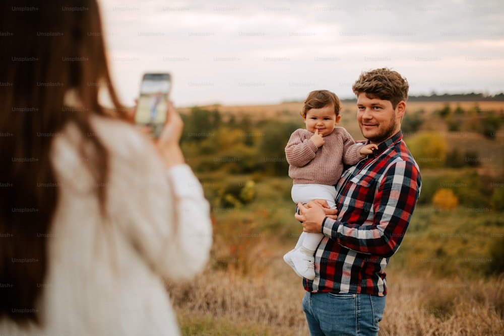 a man taking a picture of a woman holding a baby