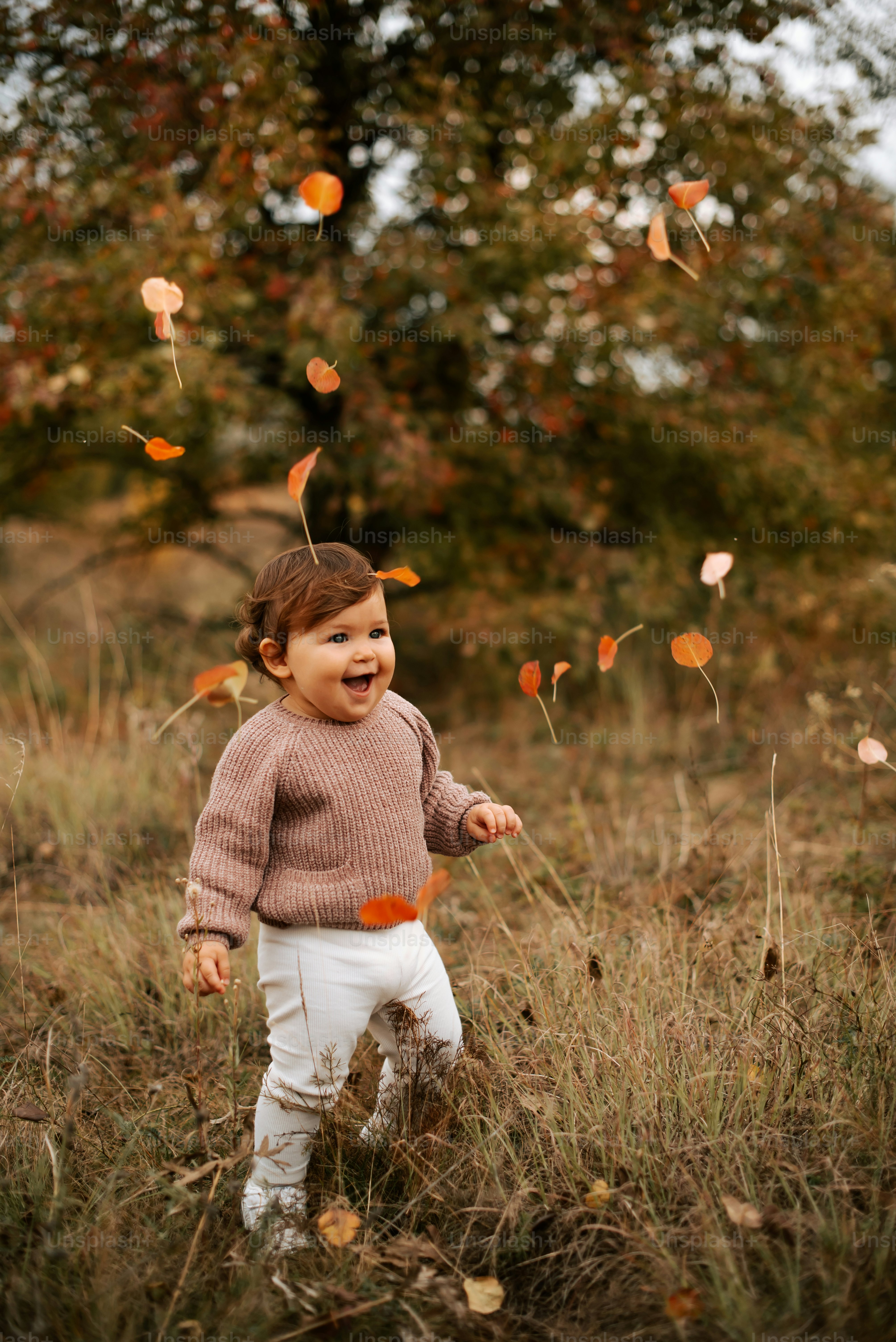 a little girl standing in a field of grass