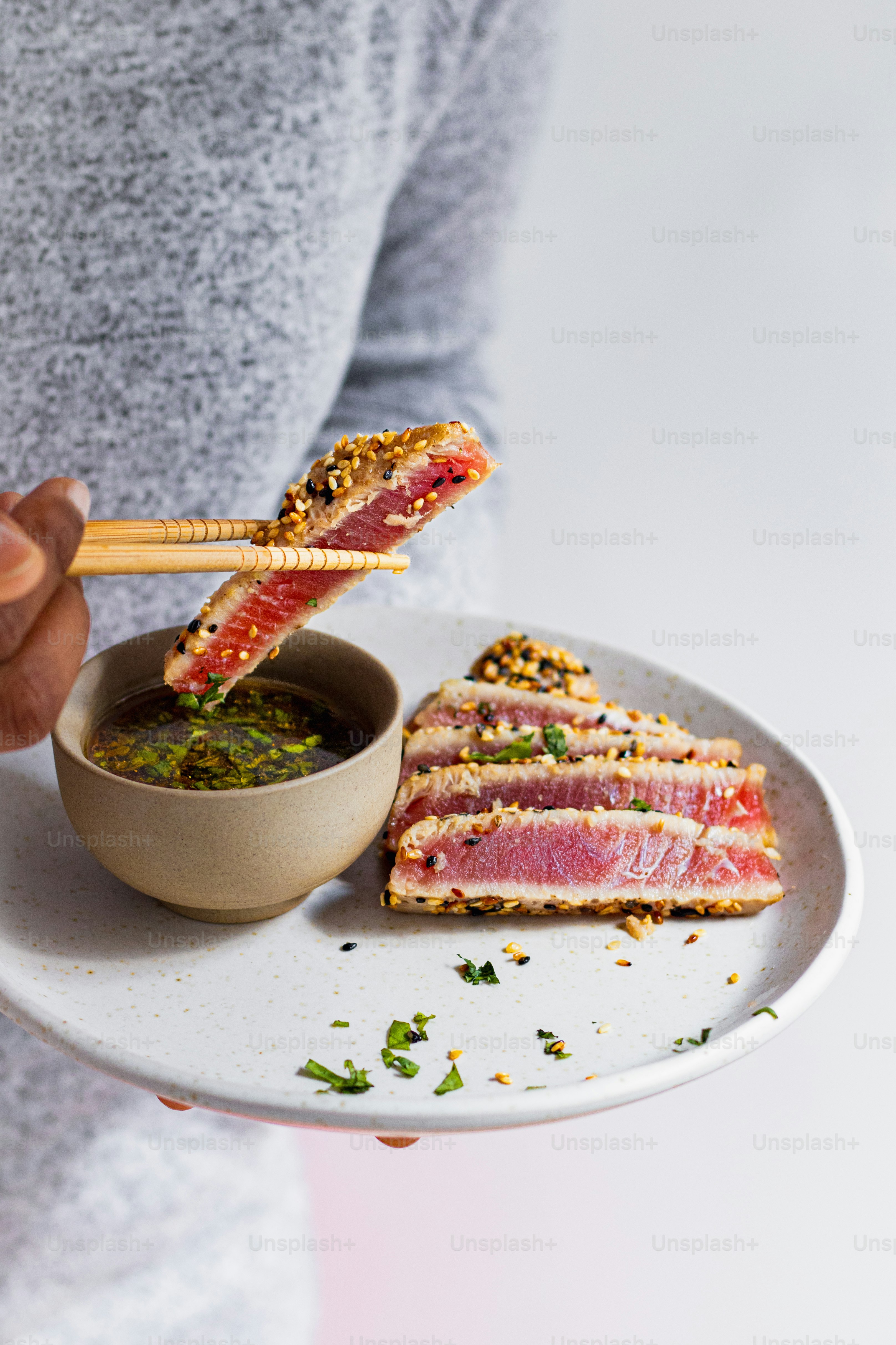 a person holding a plate with a sandwich and a bowl of soup