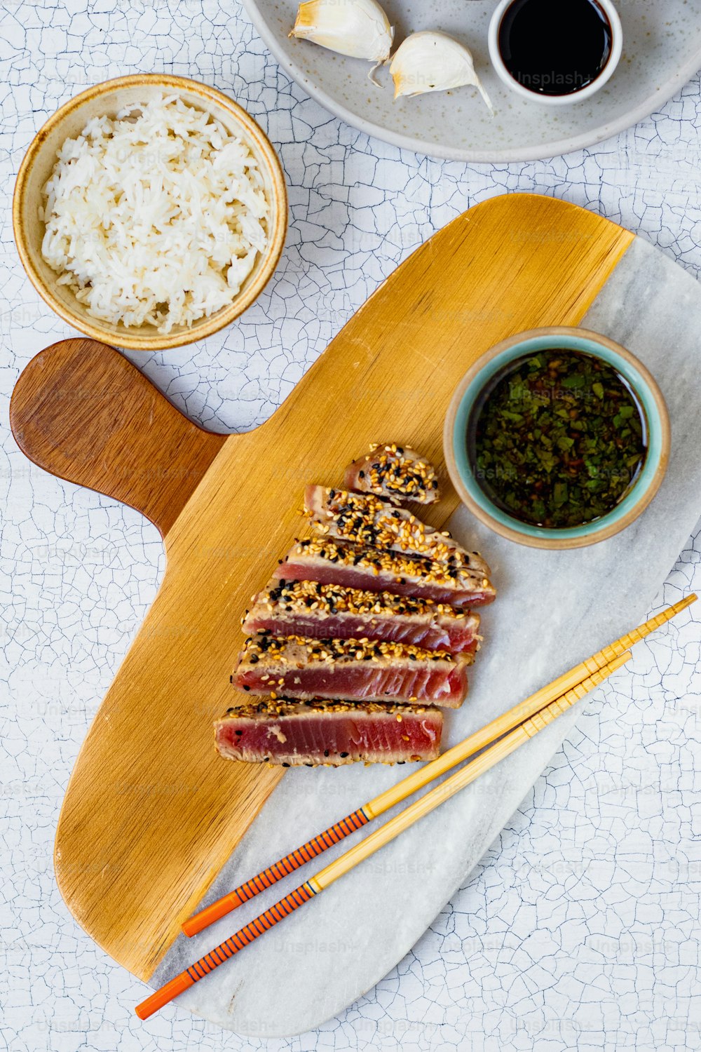 a wooden cutting board topped with meat and rice