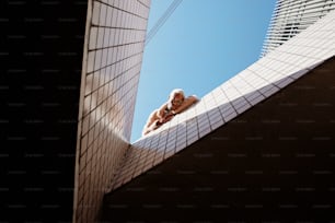 a person laying on a ledge looking up at the sky