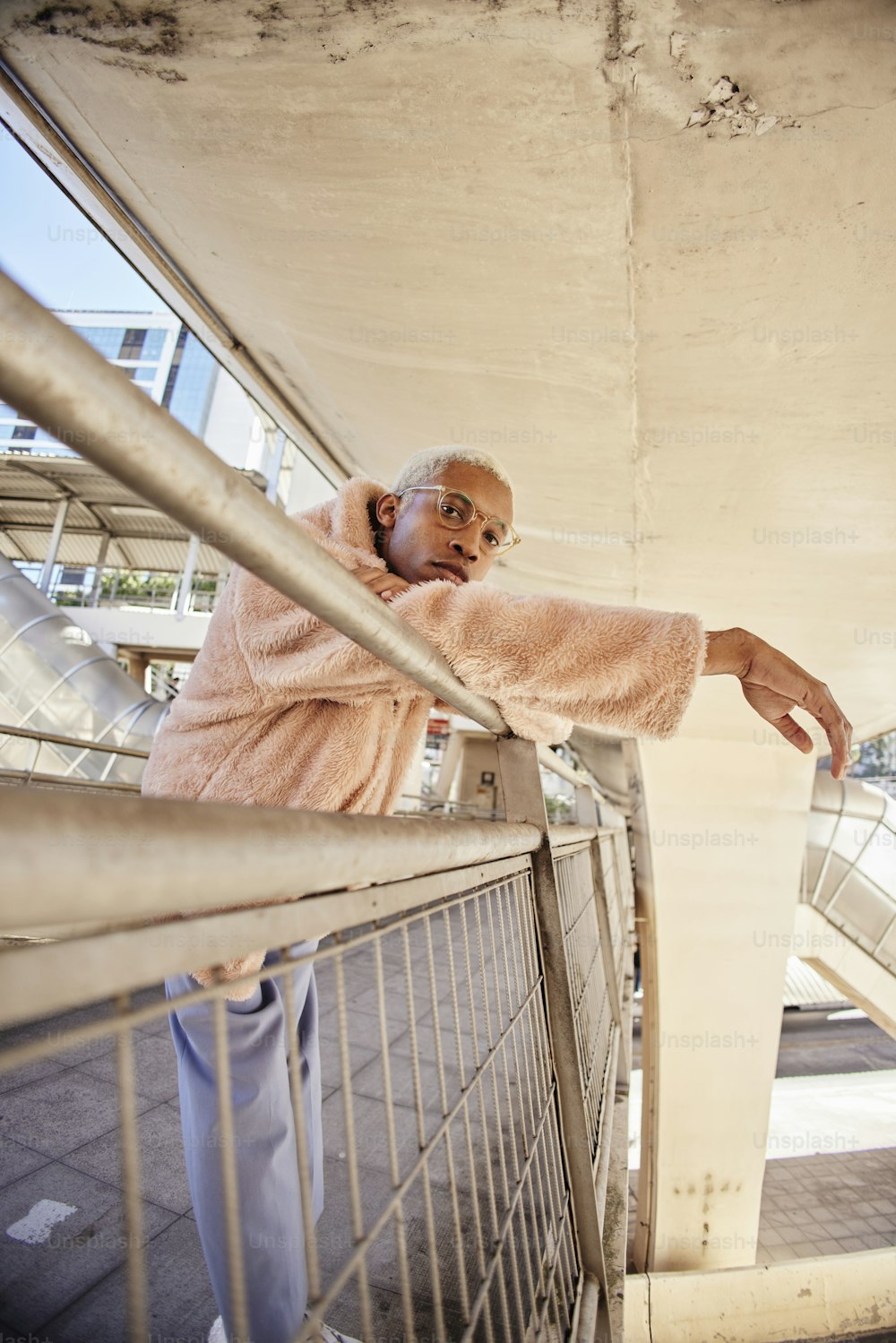 a man in a pink robe leaning on a railing