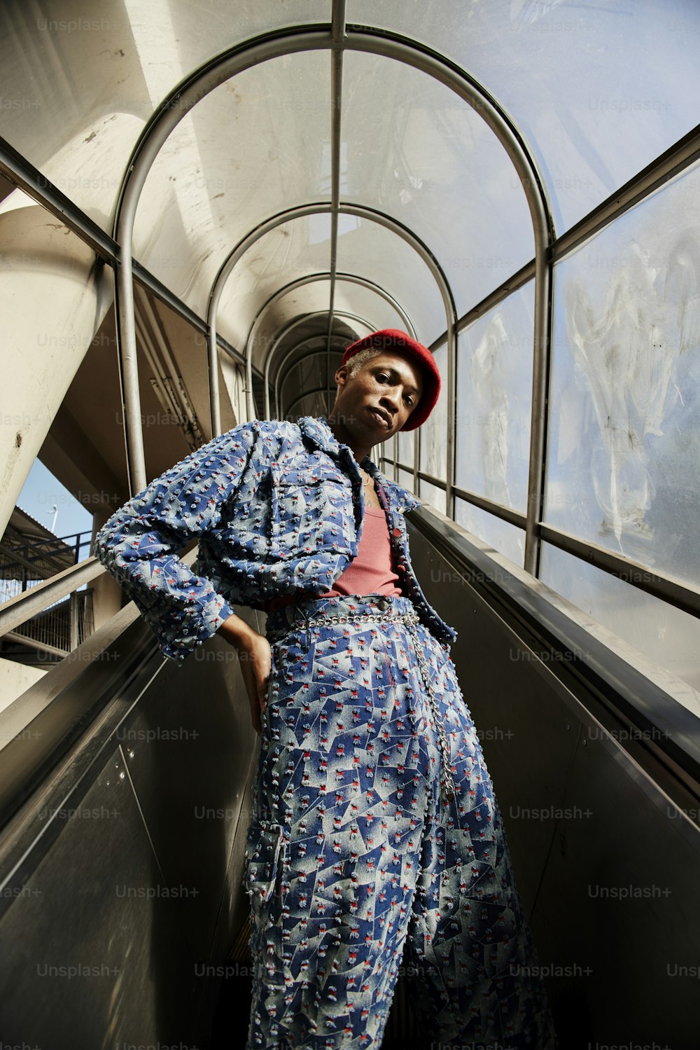 Une femme debout sur un escalator avec ses mains sur ses hanches