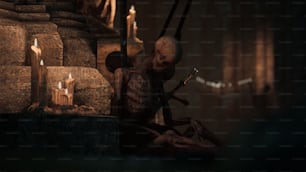 a creepy skeleton sitting in front of some candles