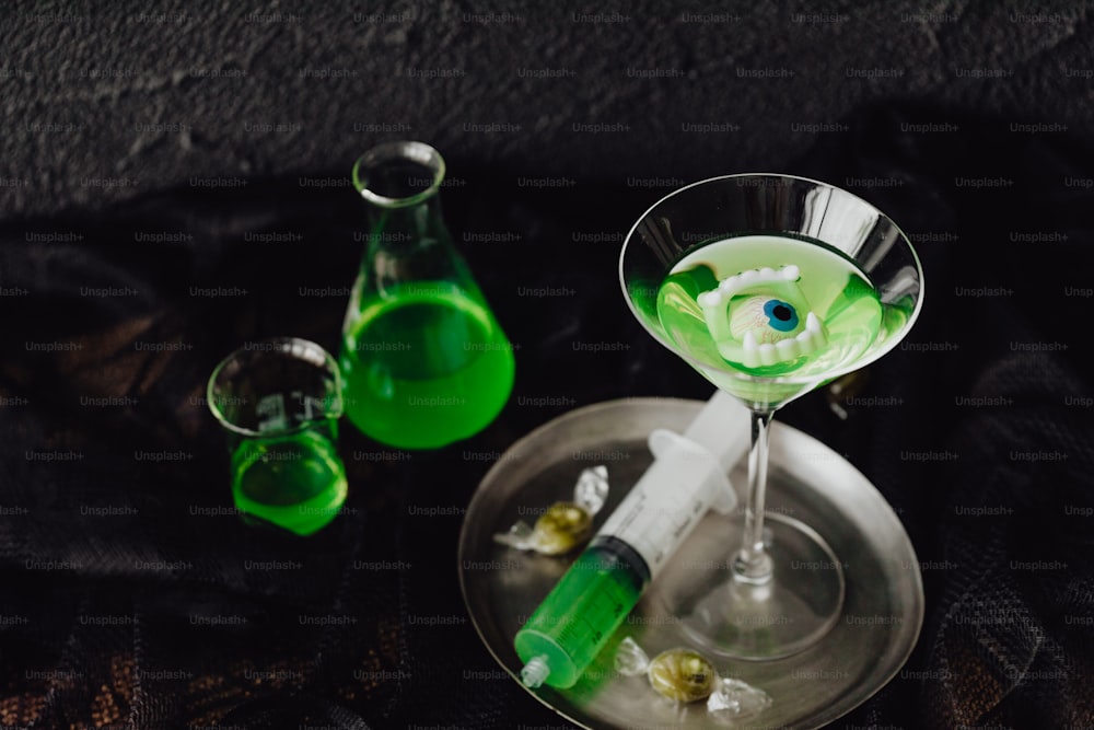 a green liquid in a martini glass with an eyeball in it