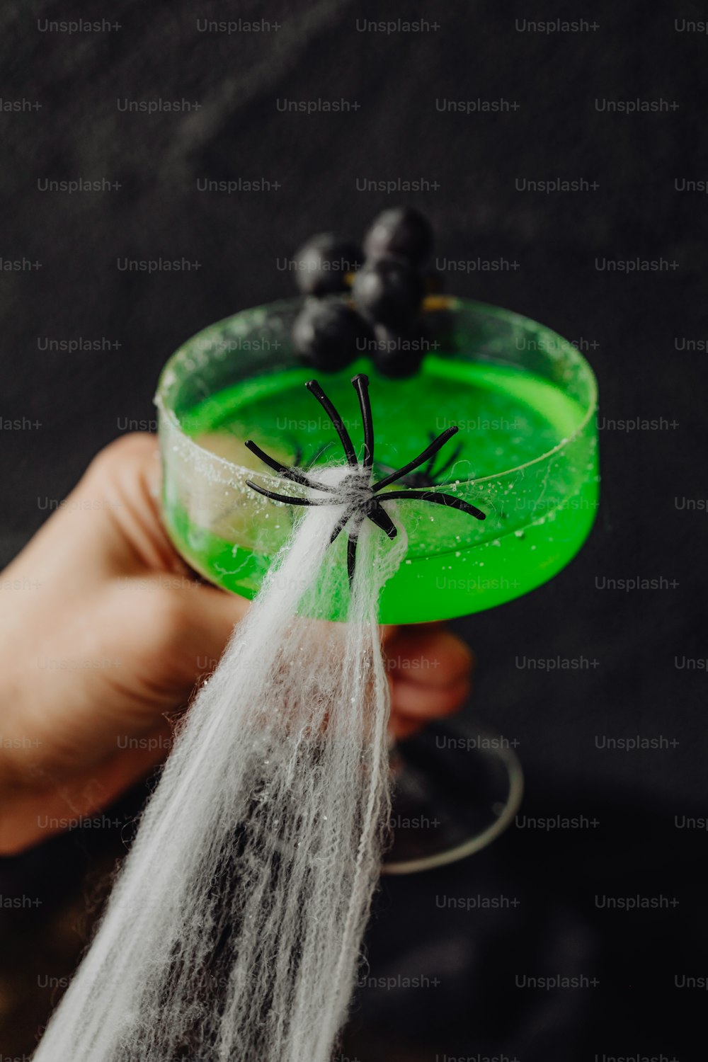 a person holding a green cup with a spider on it