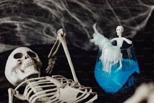 a halloween scene with a skeleton and a blue vase