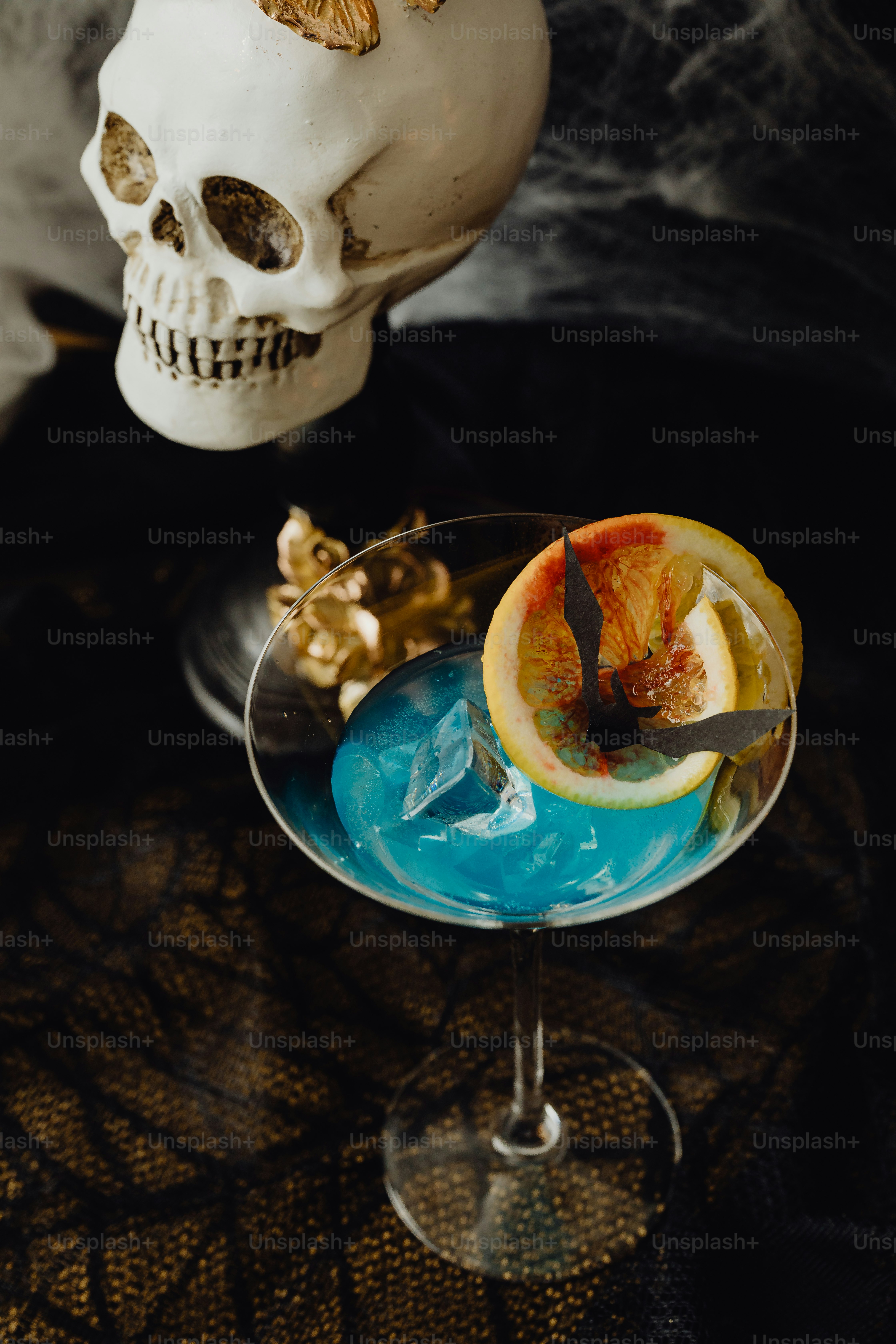 두개골이 칵테일 옆 테이블에 앉아 있습니다 사진 – Unsplash의 어두운 배경 이미지, image size:3000x4500