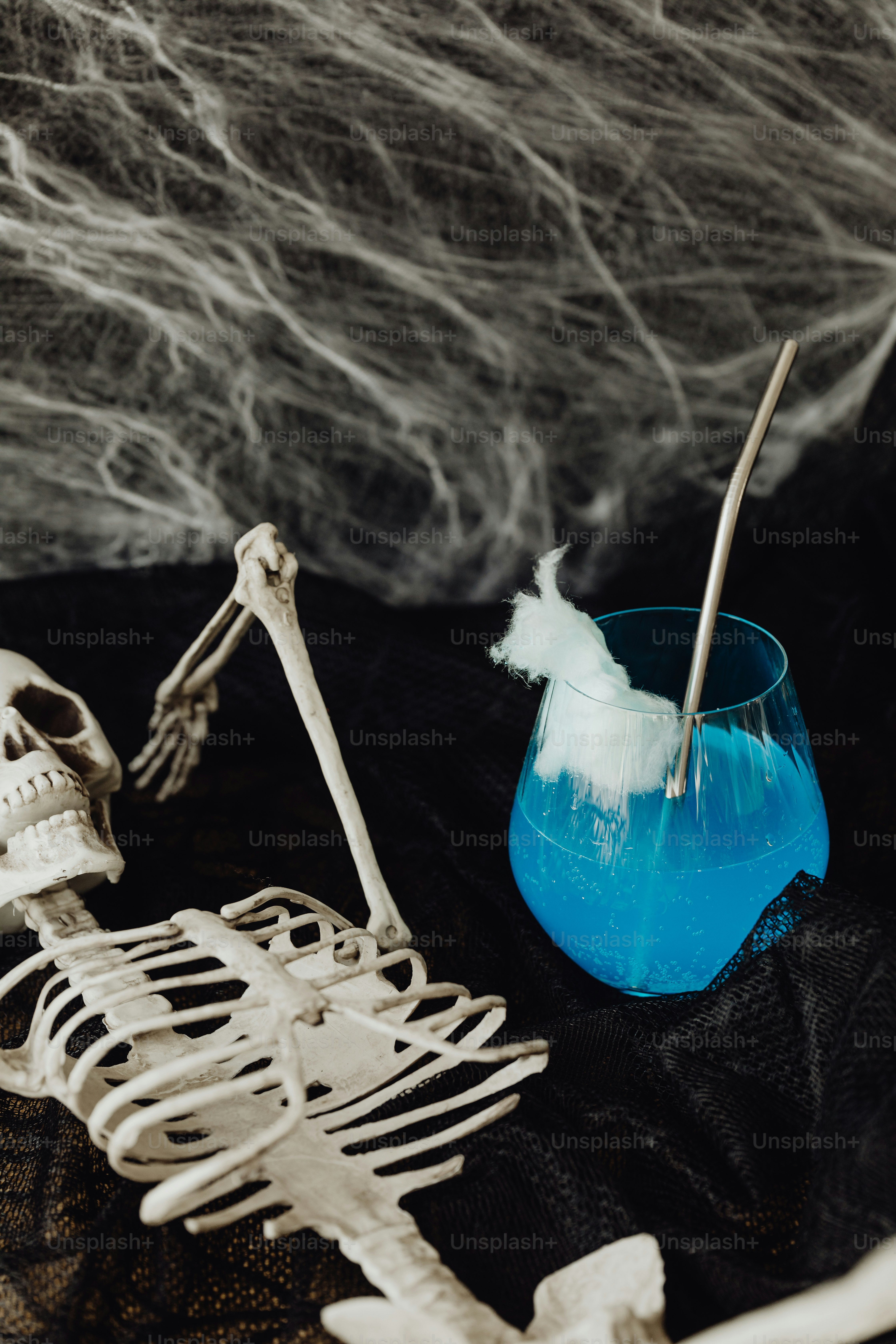 a skeleton sitting next to a blue cup with a toothbrush in it