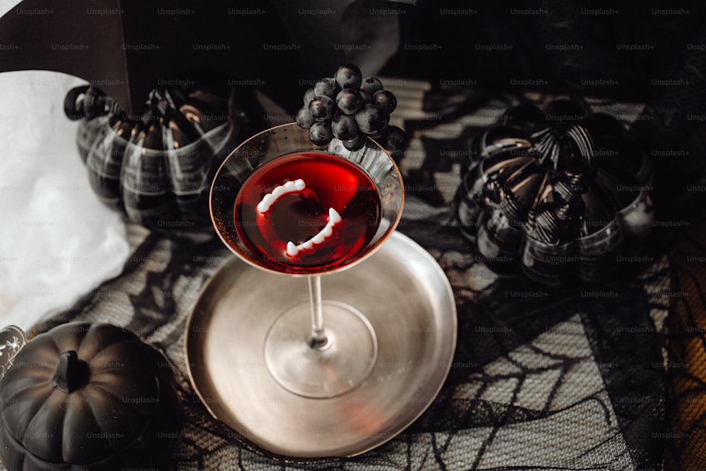 Una copa de vino tinto sentada encima de una mesa