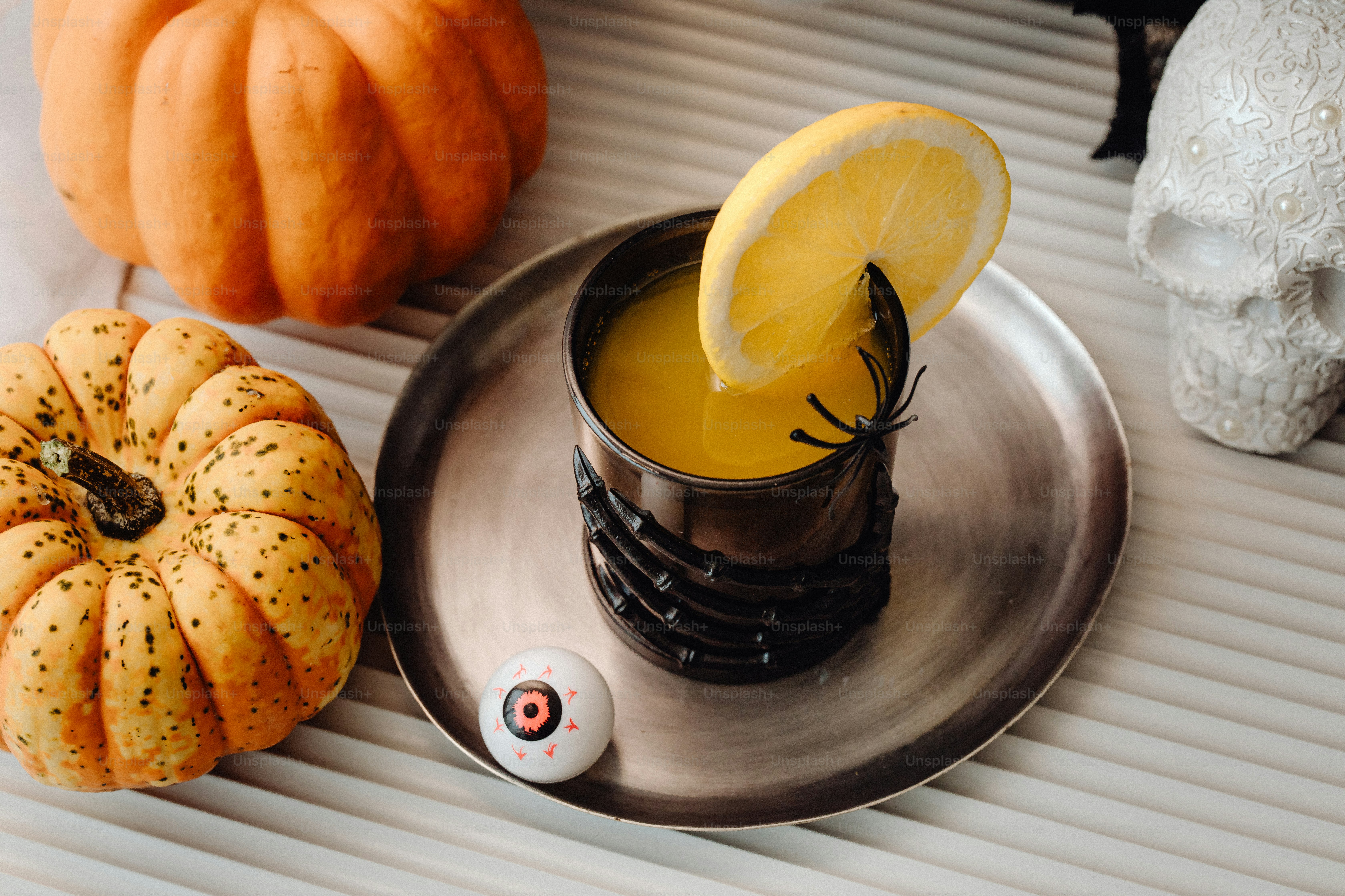 a cup of orange juice with a slice of lemon on a plate