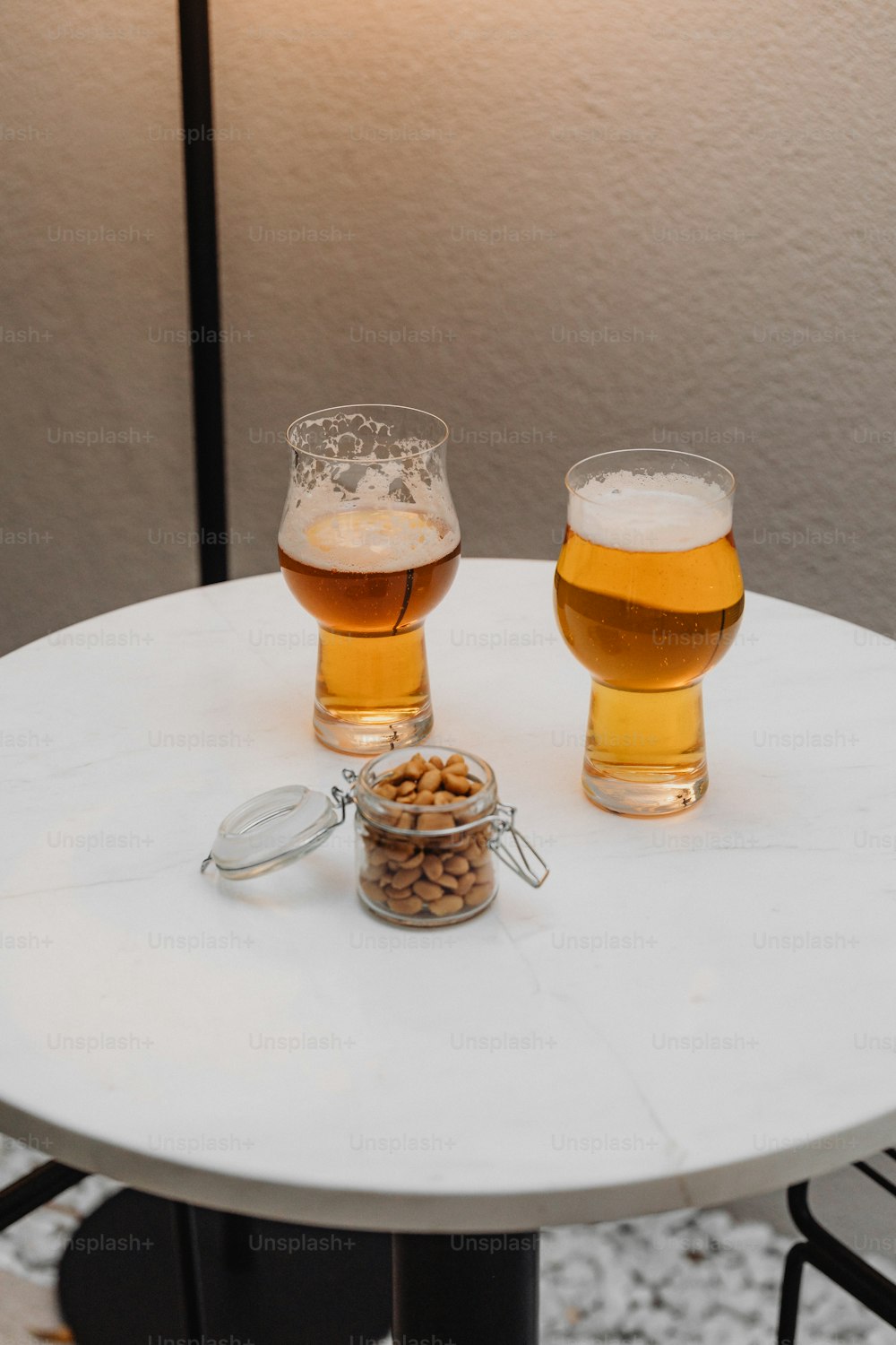 two glasses of beer sitting on a table