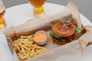 a hamburger, fries, and a drink on a table